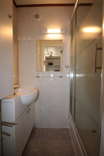 une salle de bain blanche avec un lavabo et une douche dans l'établissement Belle villa de vacances climatisée, residence TAMARIS avec accès payant pour piscines-animations, wifi, 2 chambres, 4 à 6 couchages PORTIRAGNES PLAGE LRTAMH7, à Portiragnes