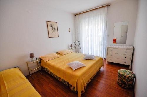 a bedroom with a bed and a dresser and a mirror at Wohnung in Novigrad mit privatem Parkplatz in Karpinjan