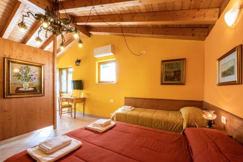 una camera con due letti in una stanza con pareti gialle di Agriturismo il Porcellino a Quinto di Valpantena