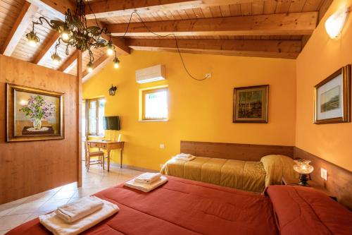 Quinto di ValpantenaにあるAgriturismo il Porcellinoの黄色い壁のベッドルーム1室(ベッド2台付)