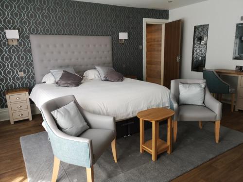 a bedroom with a bed and two chairs and a table at The Trouville Bournemouth in Bournemouth