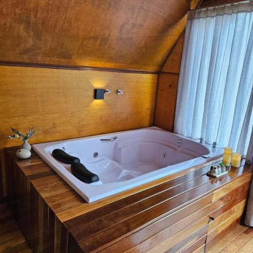 a large white bath tub in a room at Chalé de Campo com hidro in Campo Alegre