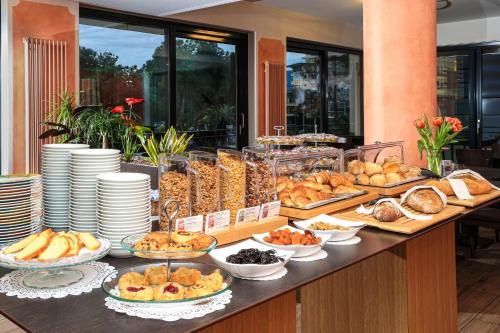 a buffet of bread and pastries on a table at Hotel Geranio Au Lac in Locarno