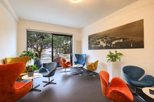 a waiting room with chairs and a large window at Hotel Geranio Au Lac in Locarno