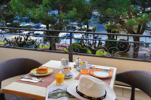 a table with a hat sitting on top of a balcony at Hotel Geranio Au Lac in Locarno