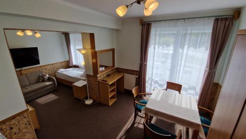 a hotel room with a mirror and a living room at Pokoje Gościnne Muszyna przy sądzie in Muszyna