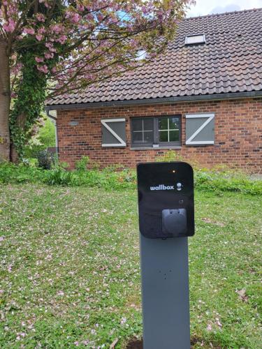 a parking meter in the grass in front of a house at B&B Le Bois de Champia in Huy