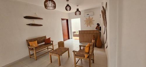 a living room with chairs and a table and a person at Chalés Mar e Sol in São Miguel do Gostoso