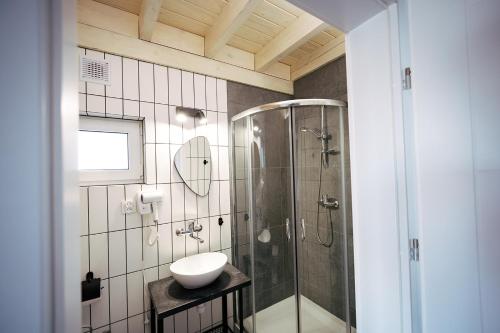 uma casa de banho com um chuveiro e um lavatório. em Skorzęcin Rybakówka Resort em Skorzęcin