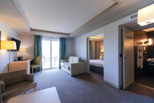 a hotel room with a bedroom and a living room at Zenitude Hotel la Valadière, an Ascend Collection Hotel in Montpellier