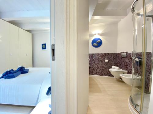 a room with a bed and a bathroom with a toilet at Guendalina in Santa Teresa Gallura