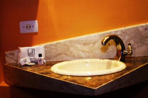 um balcão de casa de banho com um lavatório num quarto em Loft Motel em Santos