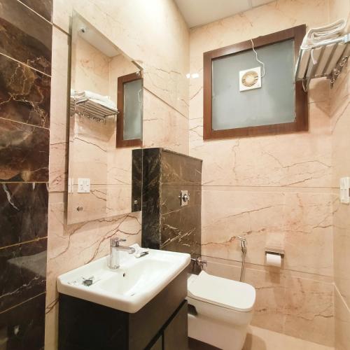 a bathroom with a sink and a toilet at Hotel East Wood Amritsar in Amritsar