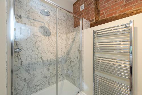 a shower with a glass door in a bathroom at The Hop Kiln in Leominster