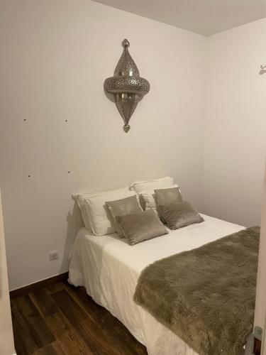 een slaapkamer met een bed met een kroonluchter erboven bij Cosy Home in Ajaccio
