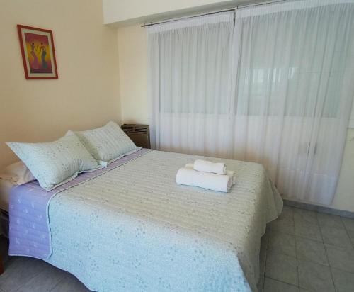 a bedroom with a bed with two towels on it at Abanico in Puerto Madryn