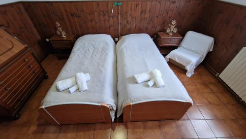2 bedden in een kamer met witte handdoeken bij Borno Good Stay! in Borno