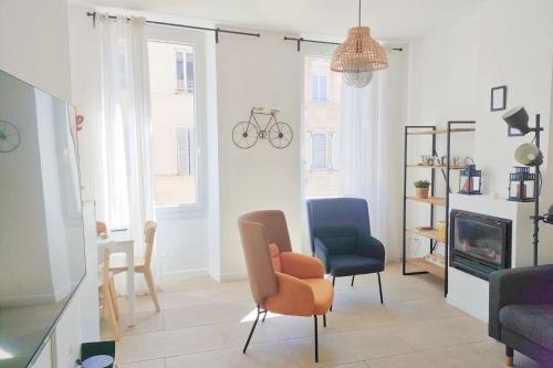 un salon avec deux chaises et une cheminée dans l'établissement Chic And Modern Apt 5 Min From The Beach, à Marseille