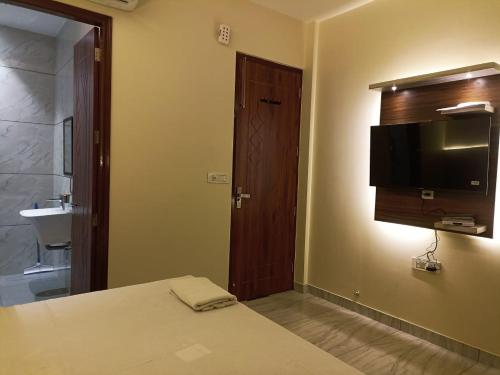 贾朗达尔Hotel G-2的卧室里有一张床，墙上有一台电视
