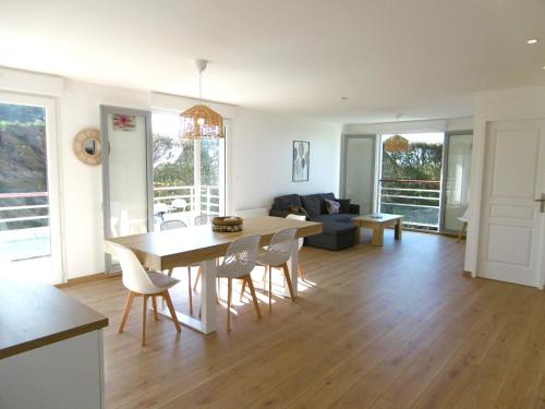 une cuisine et un salon avec une table et des chaises dans l'établissement Appartement 4 pièces 6 personnes Vue imprenable sur l'océan - Noan, à Sarzeau