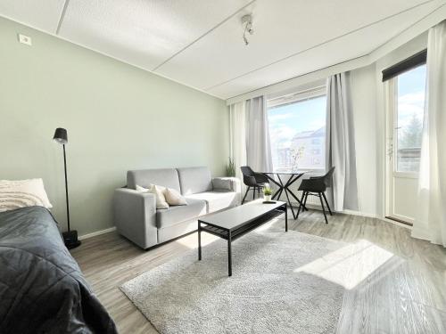 een woonkamer met een bank en een tafel bij Tammer Huoneistot - City Suite 1 - Sauna, Balcony & Free parking in Tampere