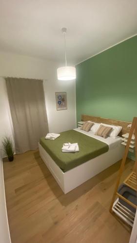 a bedroom with a large bed with a green blanket at Marsala In centro in Marsala