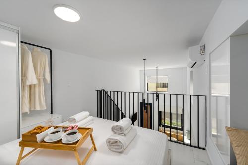 una camera bianca con un tavolo e asciugamani di Aelia Elegant Apartments a Kalamáta