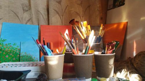 a group of cups filled with pens and pencils at Place To Reborn in Manāli