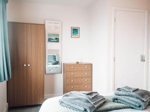 a bedroom with a bed and a dresser at Chalkhill View - Idyllic Sea Views Parking in Wyke Regis