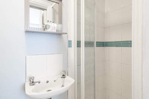 a white bathroom with a sink and a mirror at Host & Stay - Abbey View in Whitby