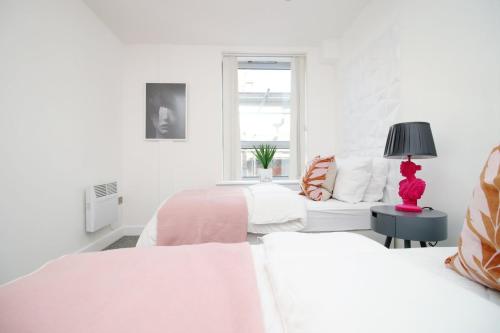 a white bedroom with two beds and a window at 2BR Near City centre in Bristol