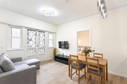 a living room with a table and a couch at Largo da Estação Apartments By Sé Apartamentos in Braga