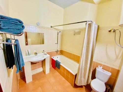 ein Badezimmer mit einer Badewanne, einem Waschbecken und einem WC in der Unterkunft Ретро паласе in Yakkasaray