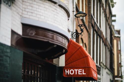 una sombrilla roja de hotel en el lateral de un edificio en Amsterdam Wiechmann Hotel en Ámsterdam