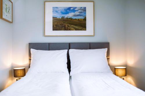 a bedroom with two beds and a picture on the wall at Sovanova Domki w Górach Sowich z Tarasem i Widokiem in Kolce