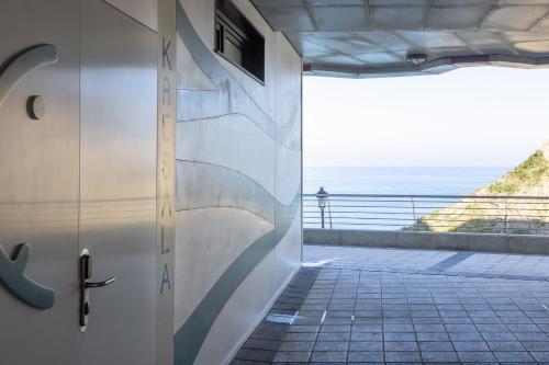 a door in a building with a view of the ocean at APARTAMENTOS KRESALA - Vistas al mar in Getaria