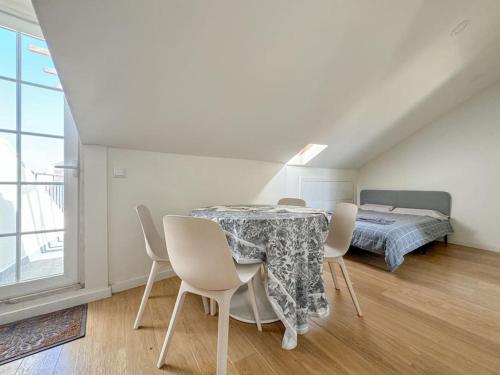 uma sala de jantar com uma mesa e cadeiras e uma cama em High Floor Terrace Apartment em Lisboa