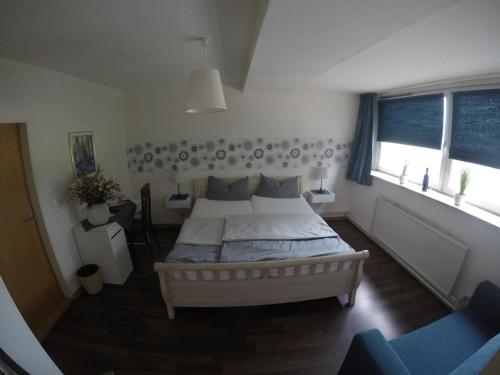 a bedroom with a large bed and two windows at Restaurant & Hotel Anglia in Steinbergkirche