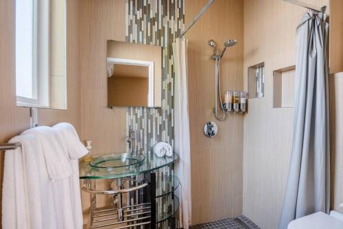 y baño con lavabo de cristal y ducha. en Modern studio within easy reach of Tech Giants, en East Palo Alto