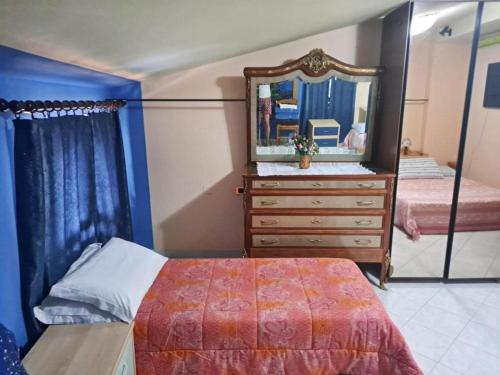 1 dormitorio con 1 cama y vestidor con espejo en Bed and Breakfast La Spina en Poggiridenti