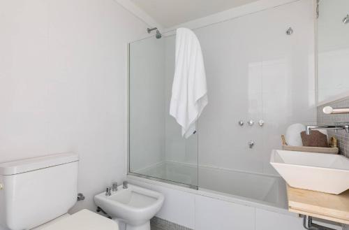 a white bathroom with a toilet and a sink at Excepcional Departamento en Nuñez in Buenos Aires