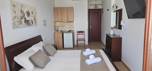 1 dormitorio con 1 cama con toallas en Amalia Studios, en Agios Prokopios