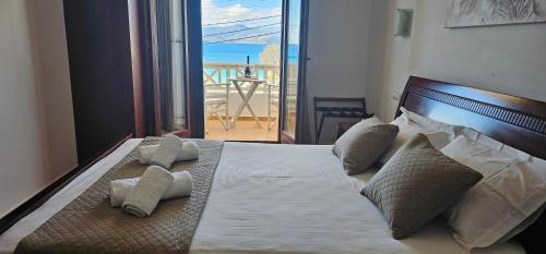 a bedroom with a bed with a view of a balcony at Amalia Studios in Agios Prokopios