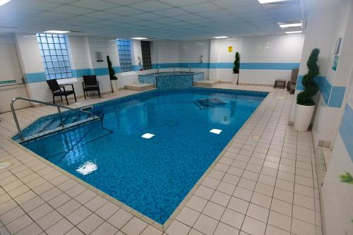 a large swimming pool in a large room at The Trouville Bournemouth in Bournemouth
