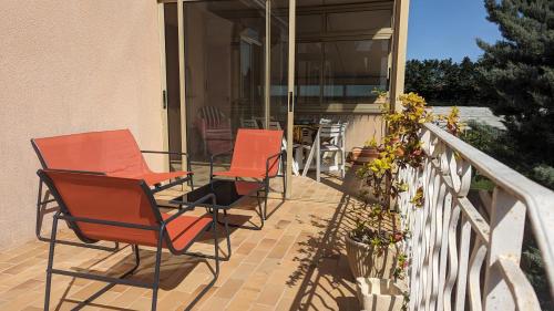 a group of chairs sitting on a porch at Gîte de campagne Clos Beau Soleil in Caumont-sur-Durance