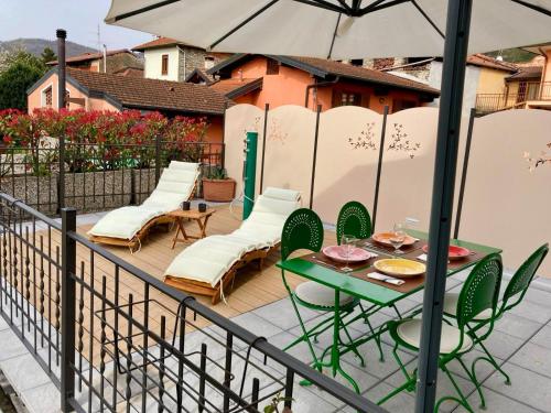 een patio met een tafel en stoelen en een parasol bij Il Gelsomino - Terrace Country House in Pisano