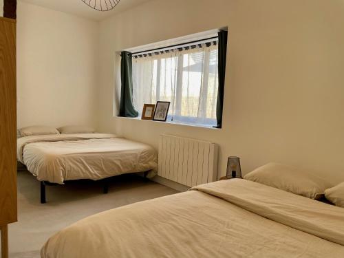 une chambre avec deux lits et une fenêtre dans l'établissement Maison avec terrasse privée proche Disneyland Paris, à Lesches