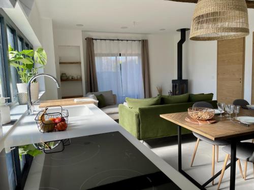 une cuisine et un salon avec un canapé et une table dans l'établissement Maison avec terrasse privée proche Disneyland Paris, à Lesches