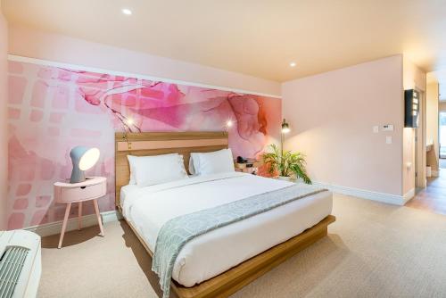 a bedroom with a large bed with a pink wall at The Bentley Hotel Southampton in Southampton