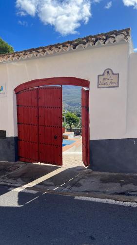 an open door to a building with a red gate at Huerta La Niña Arenas in Órgiva